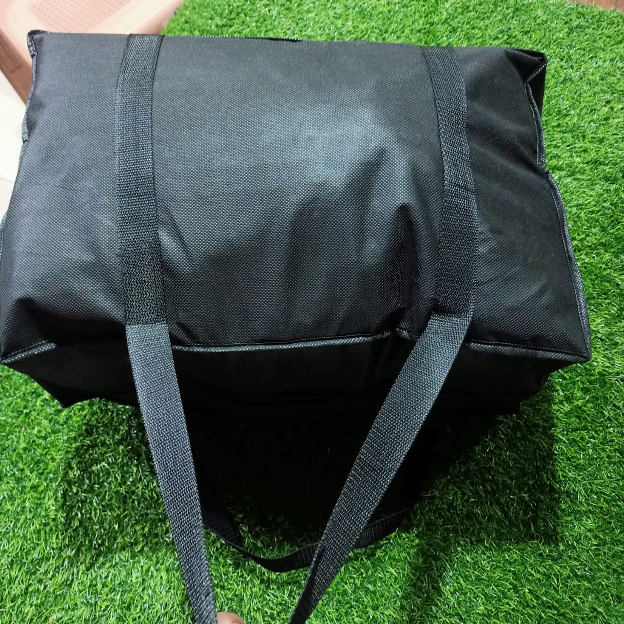 Black bag with straps on a grassy surface