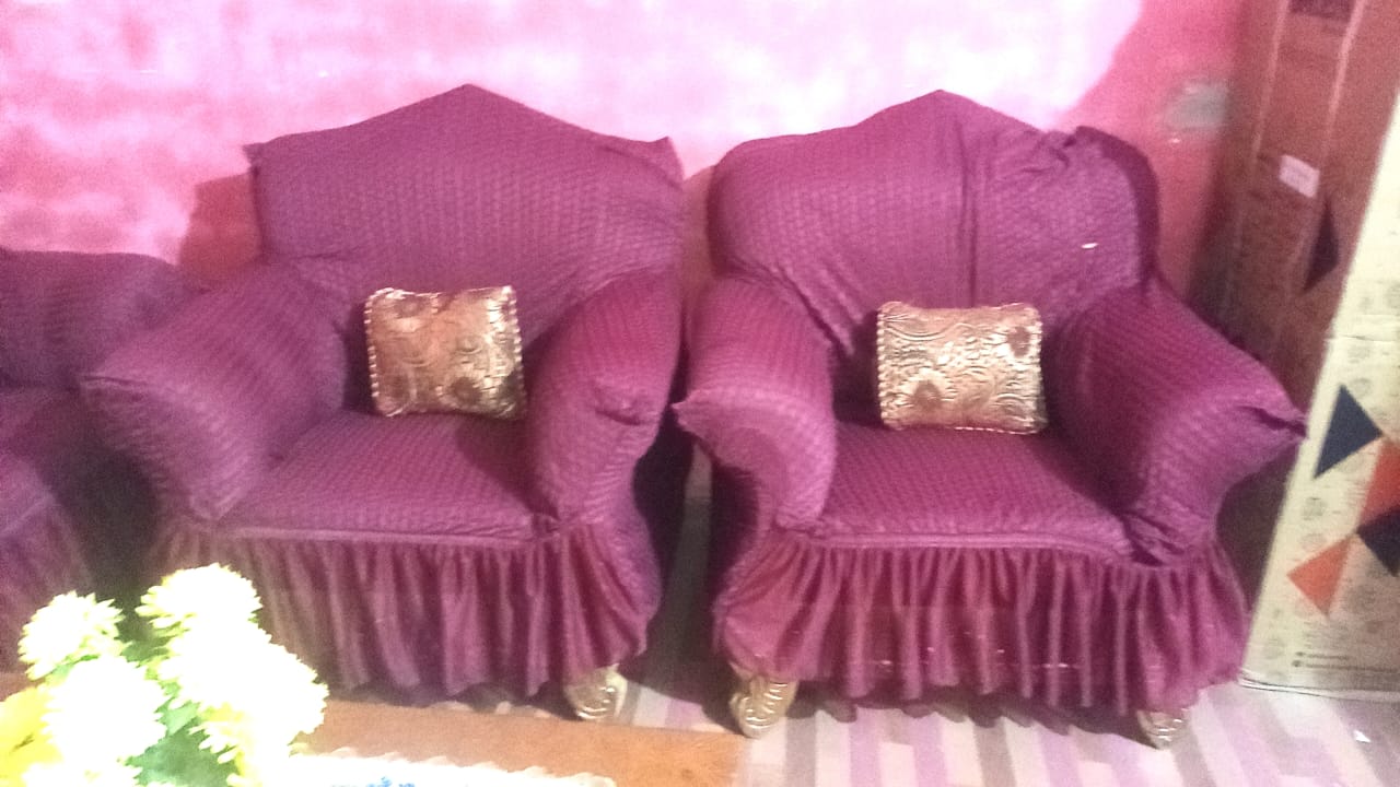 Two purple armchairs with gold cushions on a pink background