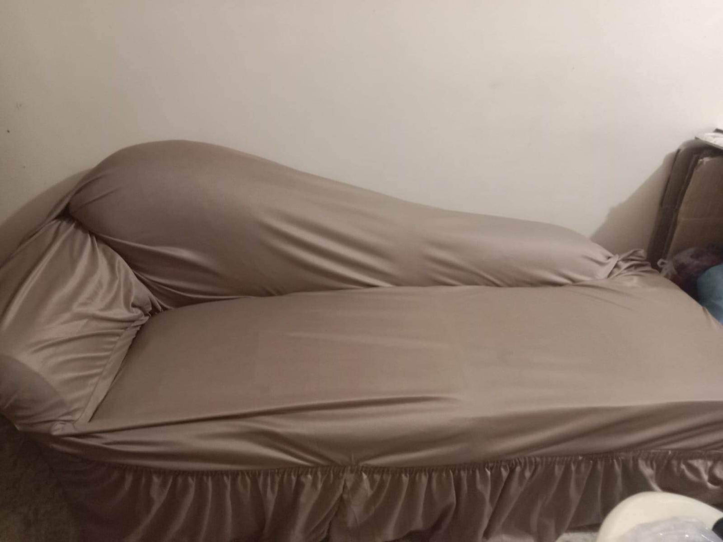 Beige bedspread on a bed against a plain wall