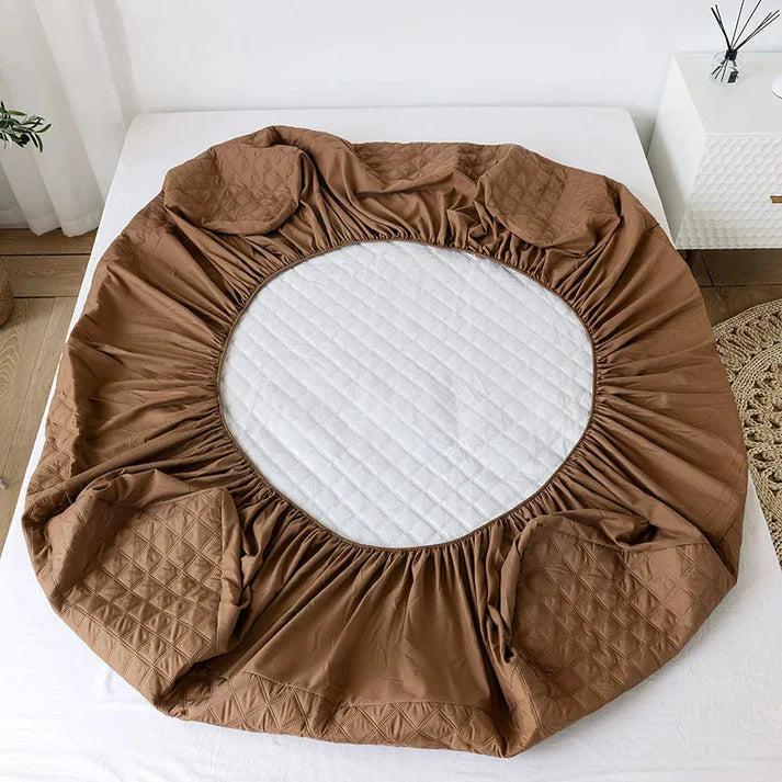 Brown fitted sheet on a mattress with a white background