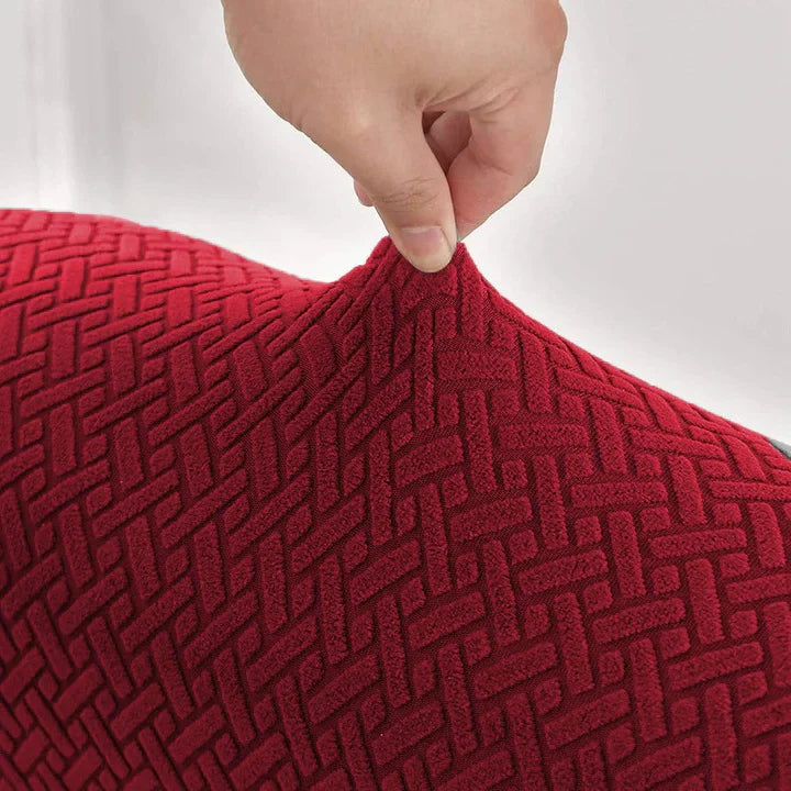Red textured fabric with a hand touching it against a white background