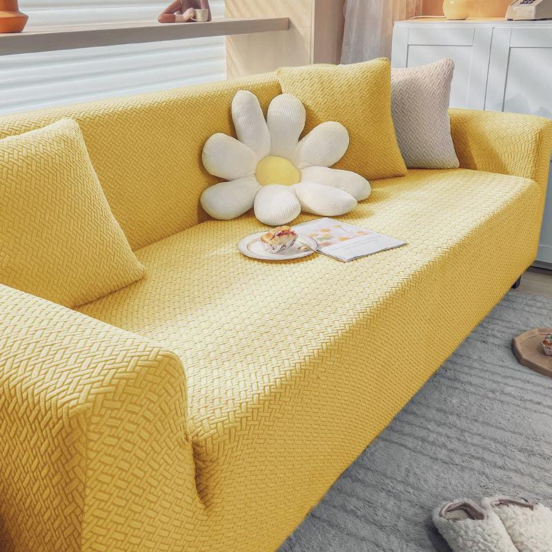 Yellow sofa with a decorative pillow shaped like a flower in a living room.