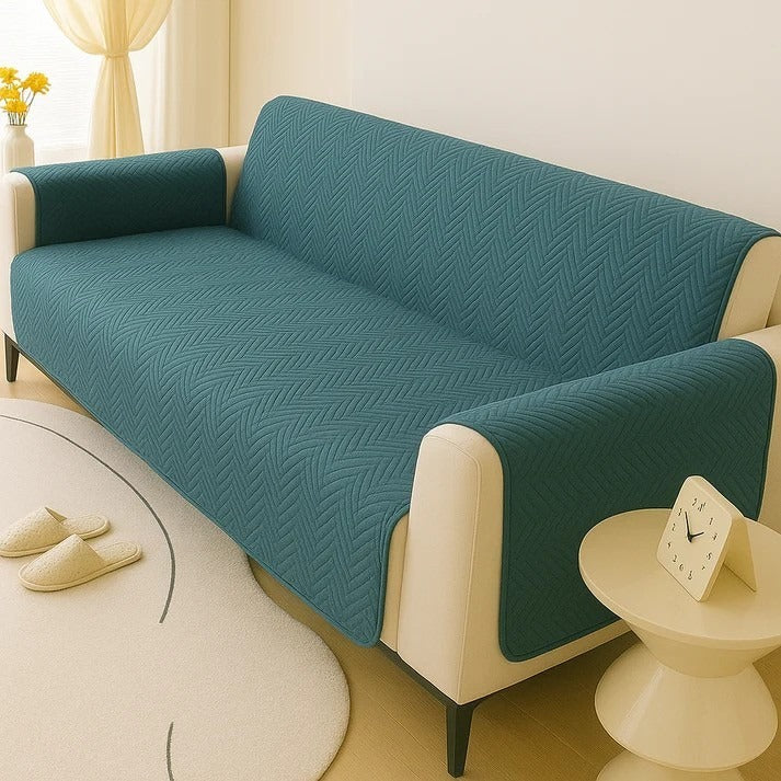 Teal sofa cover on a beige sofa in a living room setting.