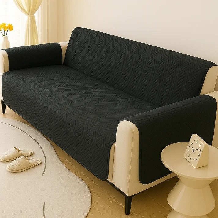 Black sofa cover on a beige sofa in a living room setting.