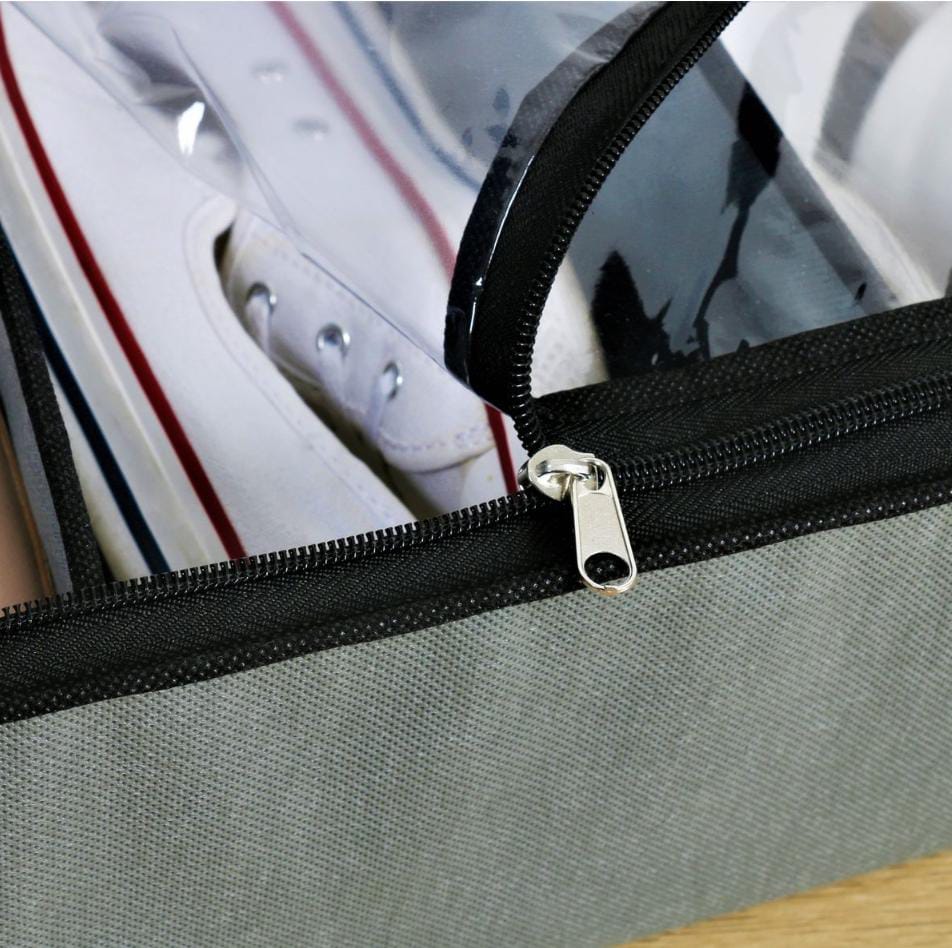 Gray shoe bag with a zipper containing a white sneaker with red and blue accents.