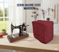 Maroon sewing machine cover on a table with a vintage sewing machine.