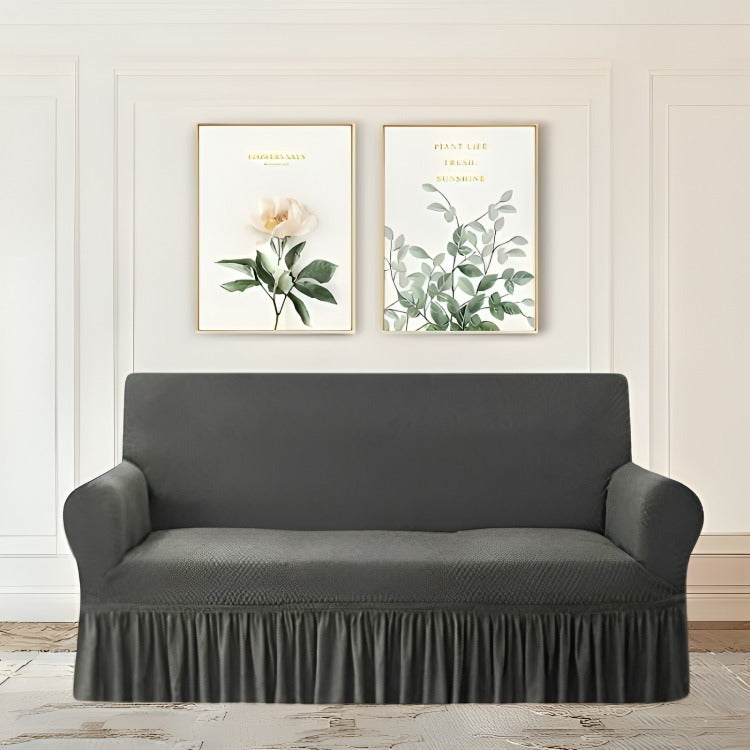 Gray sofa cover on a couch against a wall with two framed botanical prints.
