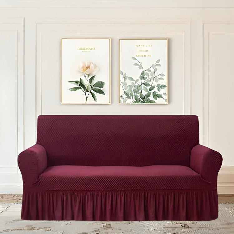 Maroon sofa cover on a couch with decorative wall art in the background