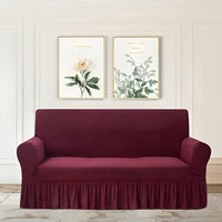 Maroon sofa cover on a couch with decorative wall art in the background