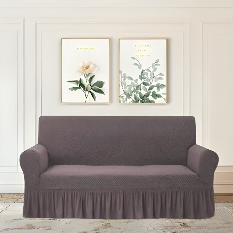 Gray sofa cover on a gray sofa with decorative wall art in the background.