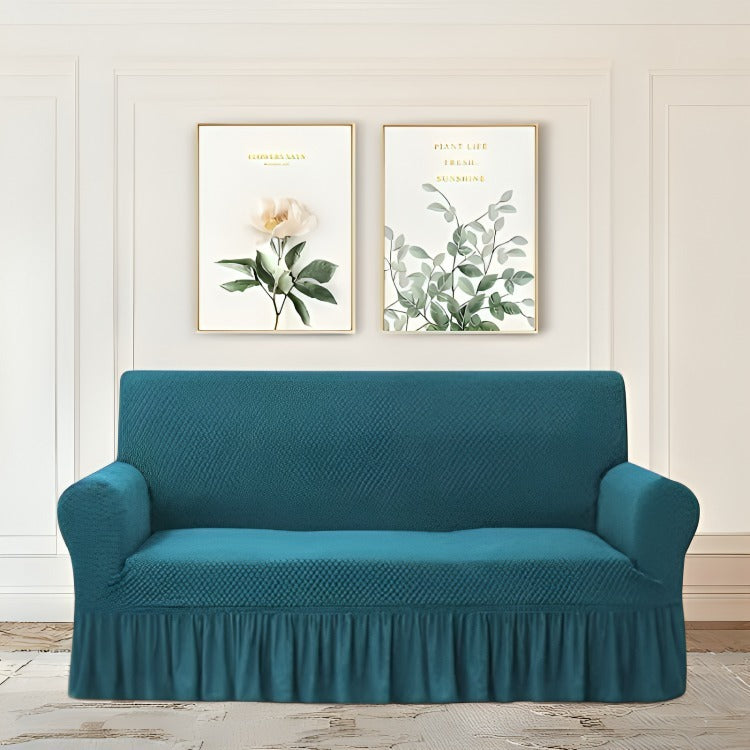 Teal sofa cover on a couch with decorative wall art in the background