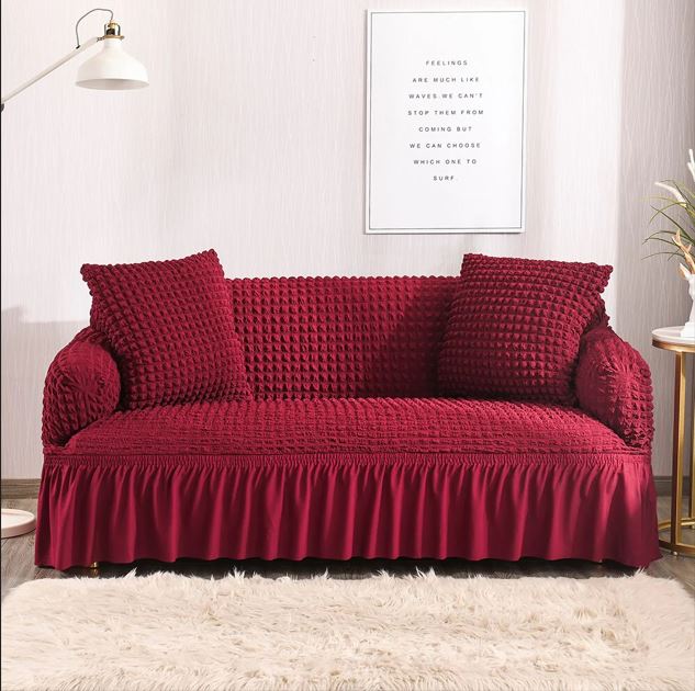 Red textured sofa with matching pillows in a room setting.