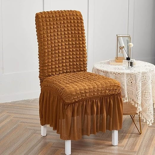Brown textured chair cover on a chair in a room with a table and decor.