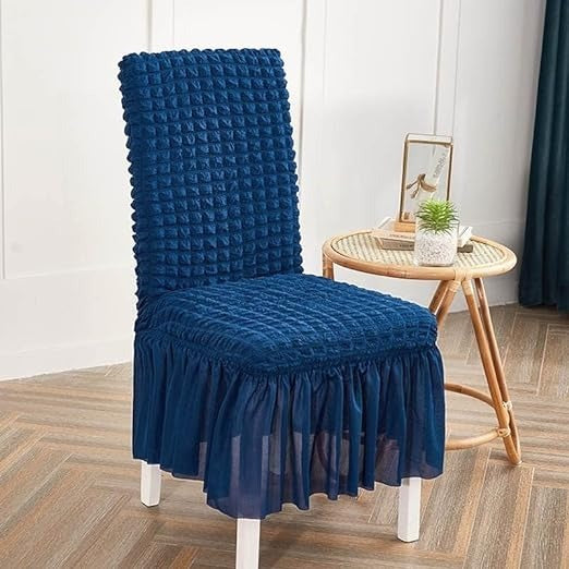 Blue textured chair cover on a chair in a room with a wooden floor and white walls.
