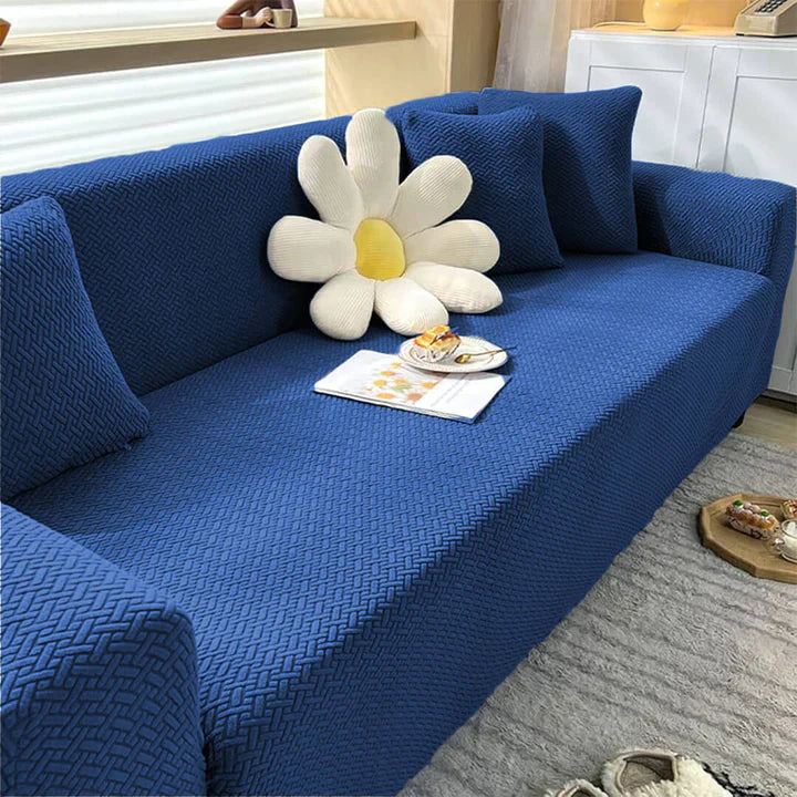 Blue sofa with a decorative pillow in the shape of a flower in a living room setting.