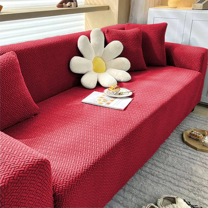 Red sofa with a decorative pillow shaped like a flower in a living room setting.