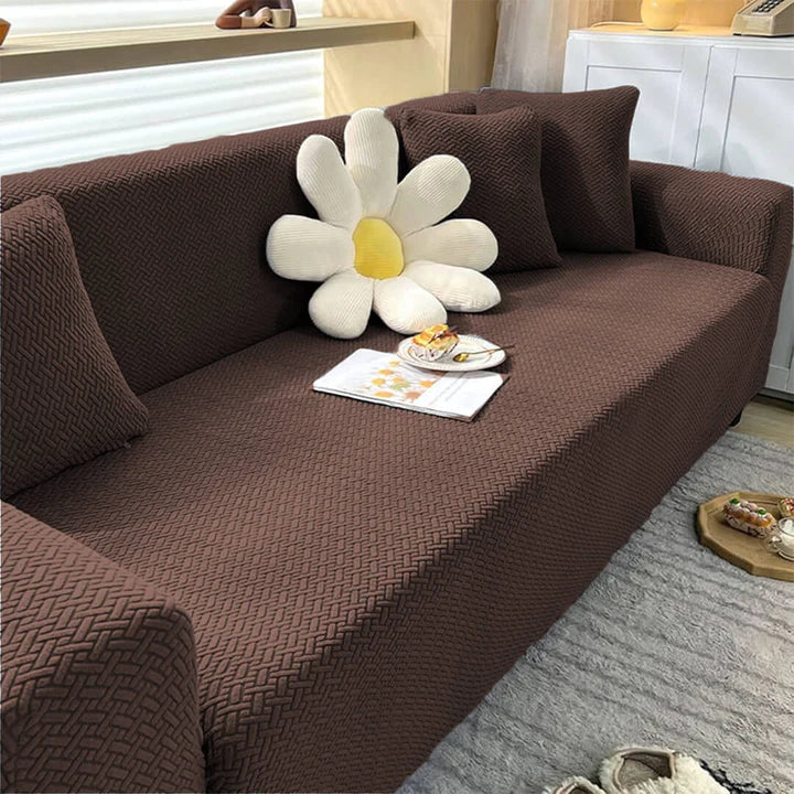 Brown sofa with a flower-shaped pillow and a plate of snacks on a gray rug.