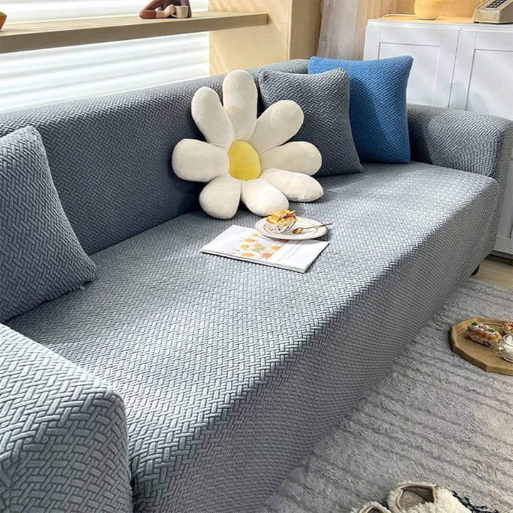 Gray sofa with decorative pillows and a large flower-shaped pillow in a living room setting.